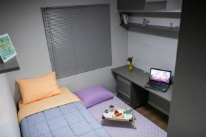 a bedroom with a bed and a desk with a laptop at B&B Apartamento Completo e Decorado com 3 Quartos in São José dos Pinhais +14 photos