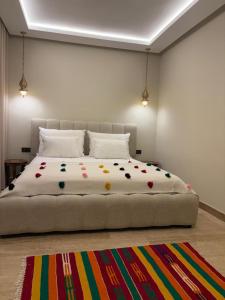 Un dormitorio con una cama grande con una alfombra colorida. en Riad Villa Alain, en Nouaceur