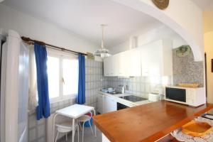 a kitchen with white cabinets and a wooden table at Chalet Carrio Park 5B in Casas de Torrat