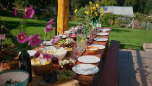 a long wooden table with plates and glasses and flowers at Cabañas Hacia El Sur in El Hoyo