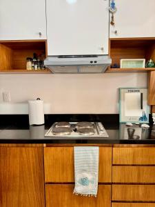 a kitchen with a stove and a microwave at Bright Ocean View Studio with Rooftop Pool Access in Puerto Morelos