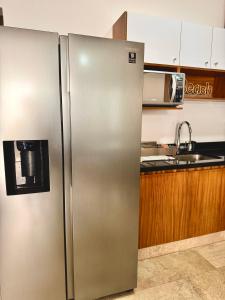 a stainless steel refrigerator in a kitchen at Bright Ocean View Studio with Rooftop Pool Access in Puerto Morelos