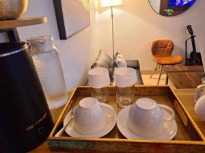 a tray with three cups and plates and glasses at Hill Residences by KJA in Manila +4 photos