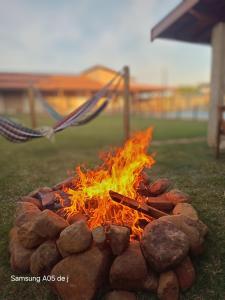 a fire pit in the grass with at Recantto dos pássaros in São Pedro