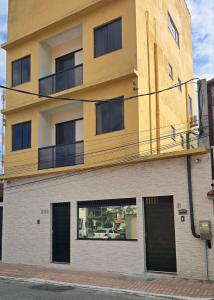 un edificio alto con porte e finestre nere di Recanto Del Mare Suítes ad Arraial do Cabo