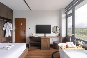 a bedroom with a desk with a tv and a bed at Scenery Boutique Dalat - Lake View in Da Lat