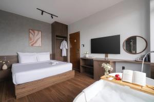 a hotel room with a bed and a tv at Scenery Boutique Dalat - Lake View in Da Lat
