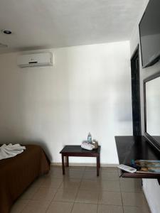 バジャドリドにあるHotel casa Don Alfonsoのベッド、テーブル、テレビが備わる客室です。