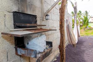 Una mesa al lado de un muro de piedra con una bolsa. en Descubre el Paraíso en Isla Isabela Apartamento a un Paso de la Playa, en Puerto Villamil 6 fotos más
