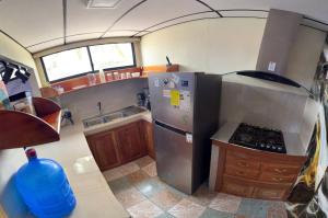cocina pequeña con nevera y fogones en Descubre el Paraíso en Isla Isabela Apartamento a un Paso de la Playa, en Puerto Villamil