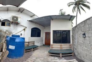 Una casa con dos barriles azules afuera de ella en Descubre el Paraíso en Isla Isabela Apartamento a un Paso de la Playa, en Puerto Villamil