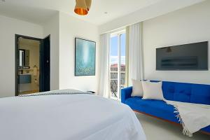 a bedroom with a blue bed and a blue couch at Beachside Heaven Sea View 1bdrm Apartment in Juan Dolio +59 photos