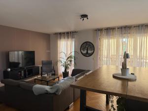 a living room with a couch and a table at Aux portes de Genève - Chambre Individuelle in Saint-Julien-en-Genevois