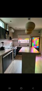 a kitchen with a counter top with rainbow windows at Hogar viedmense in Viedma