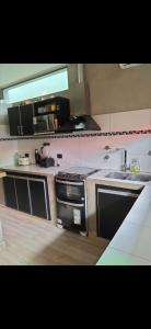 a kitchen with a stove and a sink at Hogar viedmense in Viedma