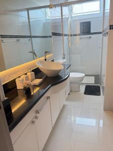 une salle de bain avec un lavabo et des toilettes dans l'établissement Apartamento Lindo com sacada vista mar! Pé na areia!!!, à Guarujá 44 autres photos