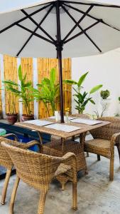 a wooden table with chairs and an umbrella at Gili Ocean Club - ADULTS ONLY in Gili Trawangan