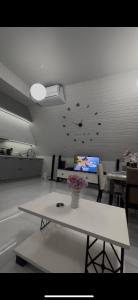 a living room with a white table and a tv at A-Frame Yaşam in İsmayıllı