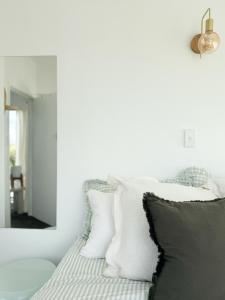 a bedroom with a bed with white and gray pillows at Nellies Nest in Dargaville