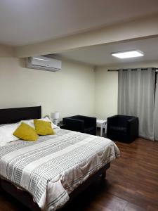 - une chambre avec un lit et 2 oreillers jaunes dans l'établissement Descanso y Trabajo en esta linda casa a pasos Casino ANTAY, à Copiapó 27 autres photos