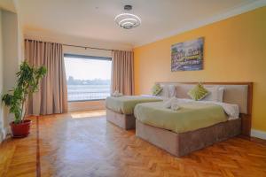 Una habitación de hotel con dos camas y una ventana. en Adorable Apartment with stunning Nile view, en El Cairo