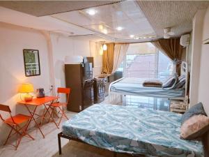 a bedroom with two beds and a table and chairs at Homestay Hostel Apartment Minh Lộc in Ho Chi Minh City +82 photos