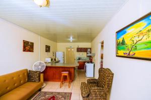 a living room with a couch and a kitchen at Carolyn's View Guesthouse in Port-of-Spain