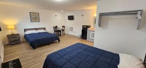 a bedroom with two beds and a table with a chair at Sunrise Inn LLC in Port Clinton
