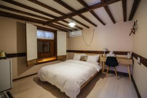 a bedroom with a bed and a desk and a window at Eosahwa in Jeonju