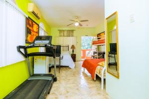 a room with a bed and a treadmill in it at Carolyn's View Guesthouse in Port-of-Spain