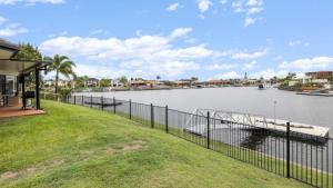 a house with a river with a boat in it at Tranquil Canal Front Holiday House in Banksia Beach