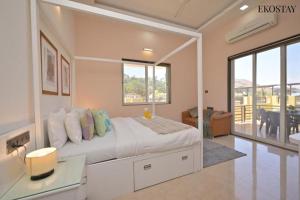 a bedroom with a bed with a desk and a balcony at Ultra Luxury 8 BHK Villa with a Private Pool in Lonavala in Khandala +23 photos