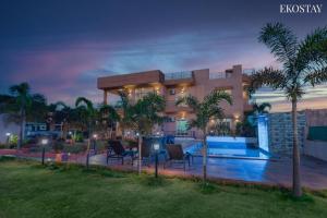 a villa with a swimming pool at night at Ultra Luxury 8 BHK Villa with a Private Pool in Lonavala in Khandala