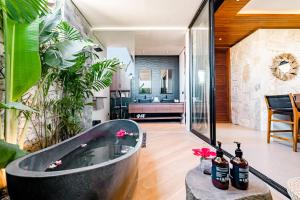 eine Badewanne in der Mitte eines Zimmers mit Pflanzen in der Unterkunft Luxury 2-Bedroom Villa with Private Pool - Uluwatu in Ungasan