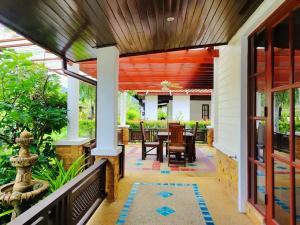 a patio with a table and chairs in a house at Secure 3 Bedroom Villa near beach in Kamala Beach