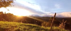Blick auf den Sonnenuntergang über einem Berg in der Unterkunft Finca Virche in Copey