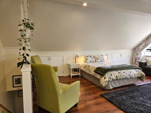 a bedroom with a bed and a chair at Fantail Farm Loft in Cambridge
