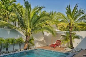 a villa with a swimming pool and palm trees at Scenic Pool Villa and Resort in Ban Huai Yai