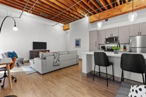 an open living room with a couch and a kitchen at Brick & Bed Riverfront Lofts, G 205 in Saint Louis