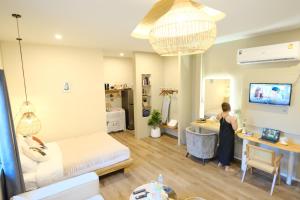 a woman in a room with a bed and a desk at Rock Reef Minimal Home in Ao Nang 