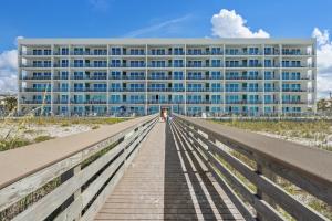 un paseo marítimo que conduce a un edificio en la playa en Blu 202 - Modern Oceanfront Luxury - Free Beach Service - Must See!, en Fort Walton Beach