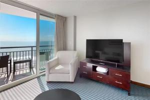 默特尔比奇Oceans One Resort 11th Floor Oceanfront Luxury Condo的带电视的客厅和阳台。