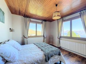 ein Schlafzimmer mit einem Bett und zwei Fenstern in der Unterkunft Chalet authentique, 15 pers, proche pistes, parking privé - FR-1-267-313 in La Toussuire