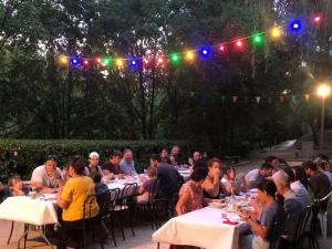 a group of people sitting at tables in a garden at Chalet spacieux pour 8 avec terrasse à Sauveterre-de-Rouergue - API-1-52-366 in Sauveterre-de-Rouergue