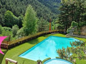 a large blue swimming pool in the middle of a yard at Mobil-home confortable avec terrasse à Meyrueis - Capacité 4 personnes - API-1-52-356 in Meyrueis