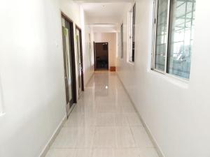 un pasillo de un edificio con paredes blancas y suelo blanco en Hotel Sskar Executive, en Pune 33 fotos más