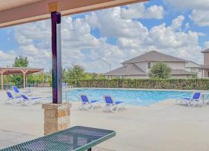 una piscina con sillas azules y una piscina en Sea World | Lackland | Pickleball | Pool!, en Riomedina