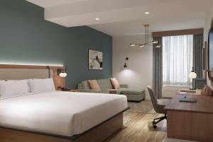 a bedroom with a large bed and a living room at Hawthorn Extended Stay by Wyndham Kilgore in Kilgore