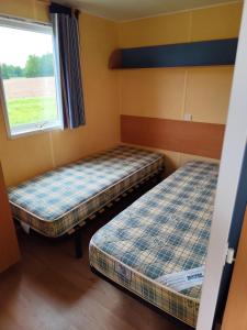 two beds in a small room with a window at La Billardière Camping à la Ferme in Le Ménil-Ciboult +32 photos