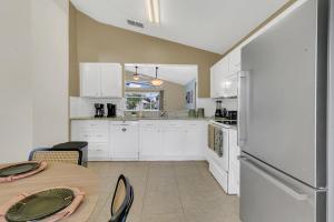 eine Küche mit weißen Schränken und einem Tisch mit Stühlen in der Unterkunft Dream Stay Orlando with a pool and home theater in Davenport